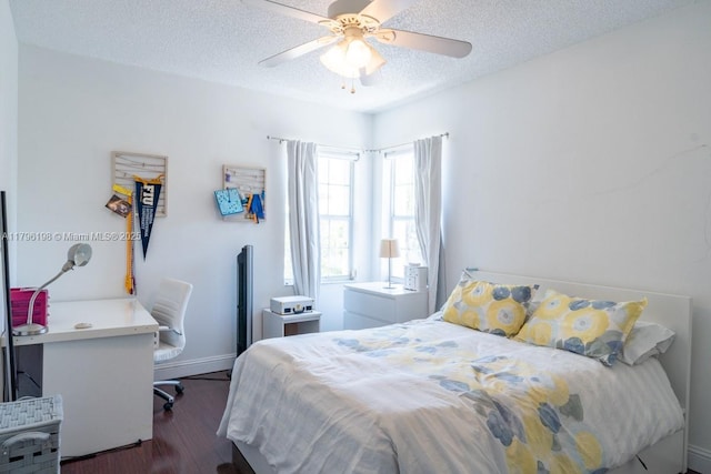 bedroom with dark wood-type flooring, a ceiling fan, a textured ceiling, and baseboards