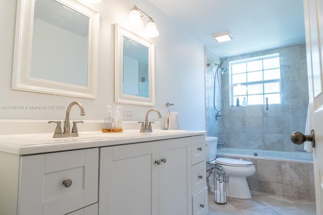 bathroom featuring vanity, tile patterned floors, tiled shower / bath, and toilet