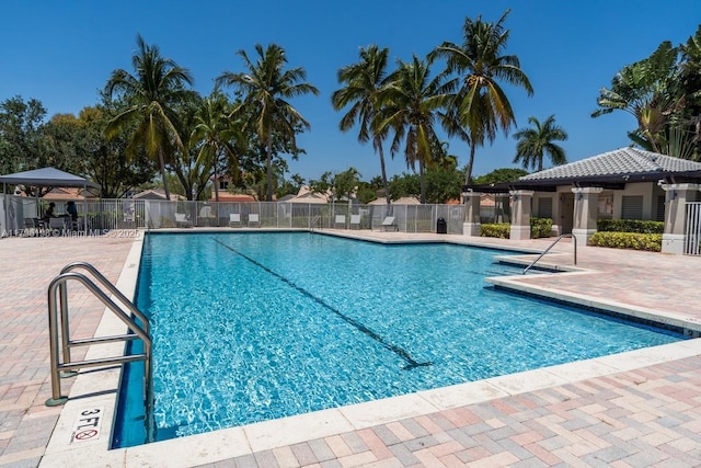 pool with a patio and fence
