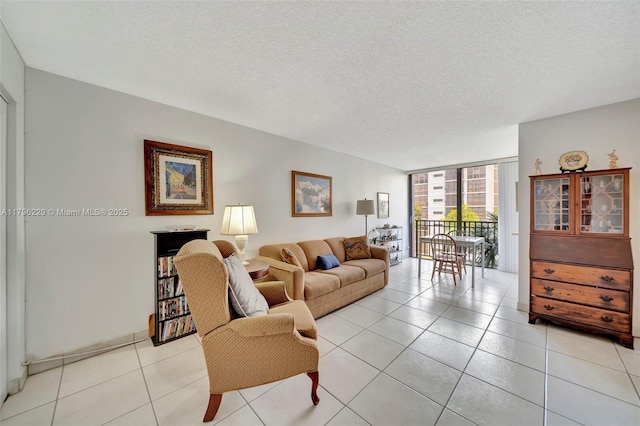 living area featuring a textured ceiling, a wall of windows, and light tile patterned floors