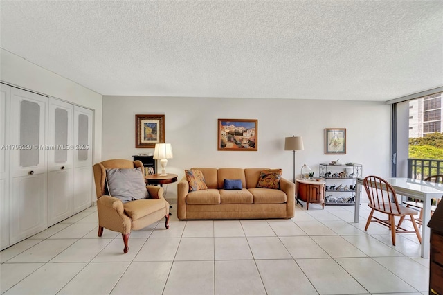 living area featuring a textured ceiling, floor to ceiling windows, and light tile patterned floors