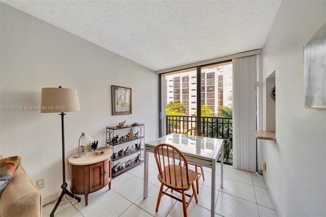 dining room with light tile patterned floors, a textured ceiling, floor to ceiling windows, and baseboards