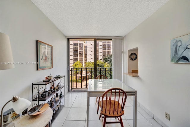 dining space featuring light tile patterned flooring, a textured ceiling, and a wealth of natural light
