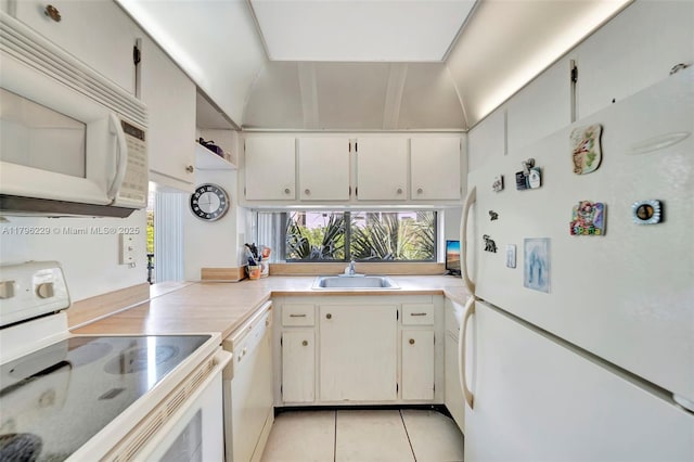 kitchen with a sink, light tile patterned flooring, white appliances, and light countertops