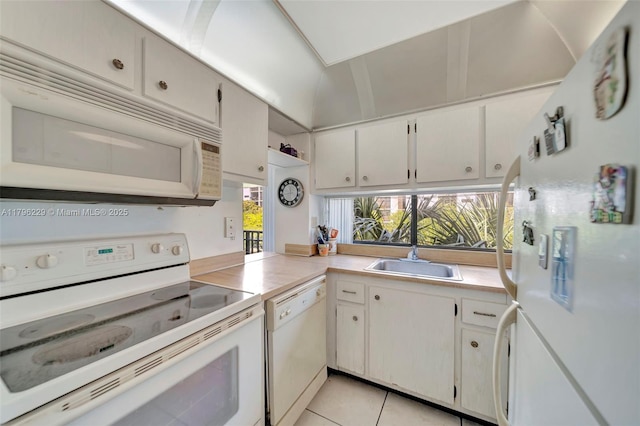 kitchen featuring white appliances, light tile patterned floors, a sink, and light countertops