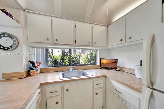 kitchen featuring freestanding refrigerator, a sink, and light countertops