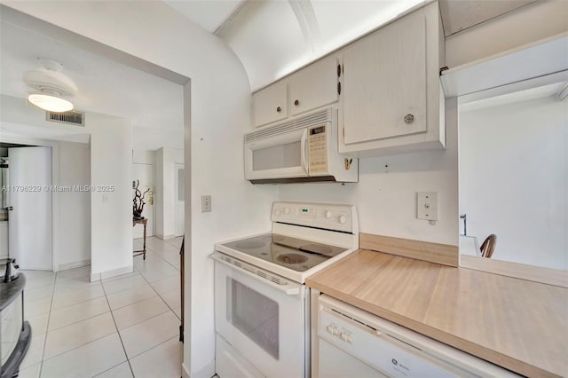 kitchen featuring visible vents, light countertops, light tile patterned floors, and white appliances