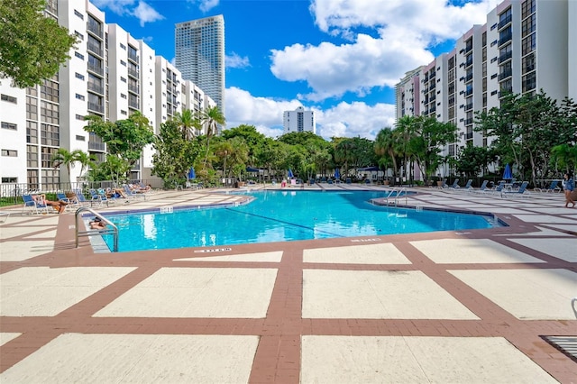 community pool featuring a view of city and a patio area