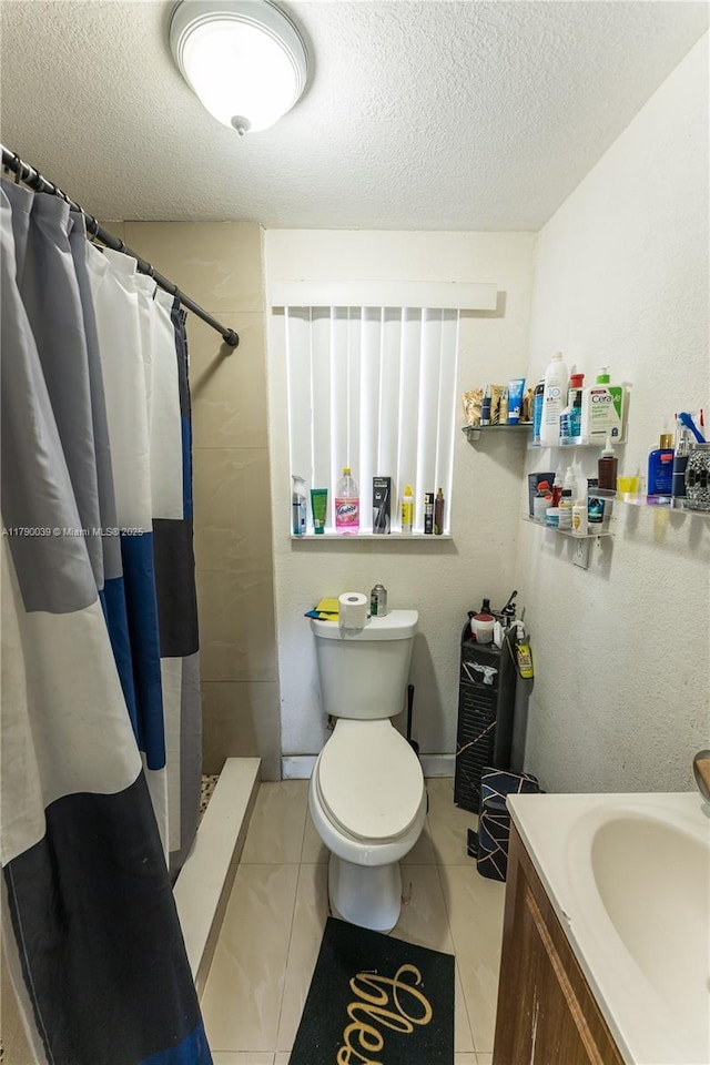 bathroom with toilet, a textured ceiling, a shower with shower curtain, and tile patterned flooring