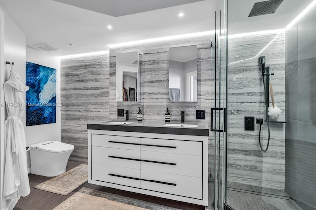 full bath with double vanity, toilet, a sink, and a stall shower
