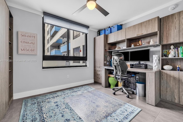 office featuring baseboards, a ceiling fan, and built in desk