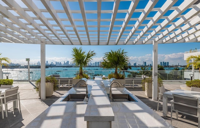 view of patio featuring a view of city, a water view, a pergola, and a sink