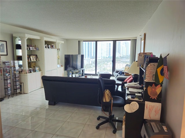 living area featuring a textured ceiling, floor to ceiling windows, and light tile patterned flooring