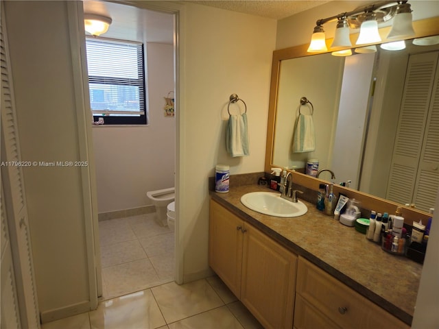 bathroom with a bidet, tile patterned flooring, vanity, baseboards, and a closet