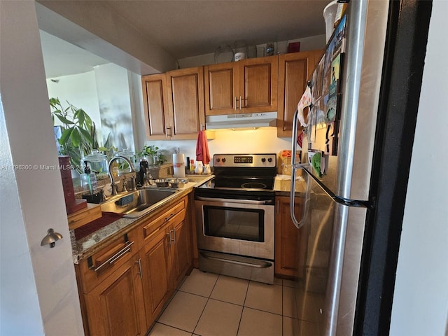 1035 W Ave Unit 406, Miami Beach, FL 33139 - kitchen featuring stainless steel appliances, under cabinet range hood, brown cabinetry, and light tile patterned flooring