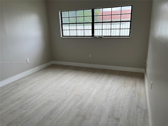 empty room with baseboards and wood finished floors