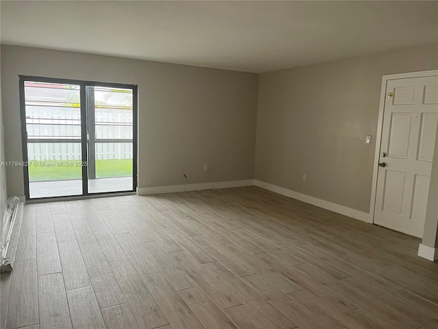 empty room with baseboards and wood finished floors