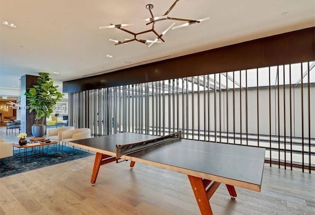 game room with wood finished floors and a notable chandelier
