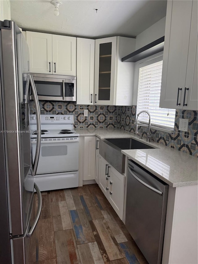 3800 NE 21st Ave Unit 12, Lighthouse Point, FL 33064 - kitchen featuring dark wood-style flooring, stainless steel appliances, white cabinets, and tasteful backsplash