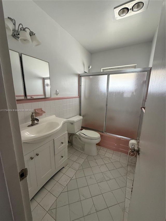 3800 NE 21st Ave Unit 12, Lighthouse Point, FL 33064 - bathroom with vanity, shower / bath combination with glass door, toilet, tile walls, and tile patterned floors