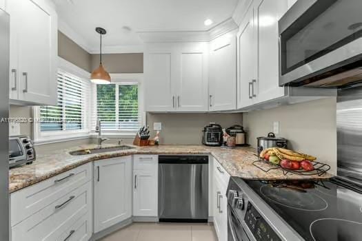 kitchen featuring a sink, light stone counters, white cabinets, a toaster, and stainless steel appliances