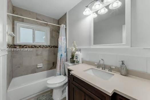bathroom featuring toilet, shower / bath combination with curtain, and vanity