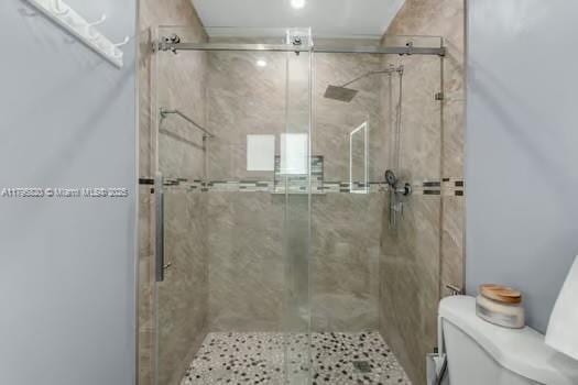 full bathroom featuring toilet and a stall shower