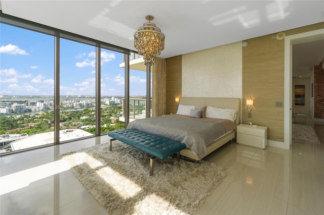 bedroom featuring a notable chandelier, a wall of windows, tile patterned floors, wallpapered walls, and a city view