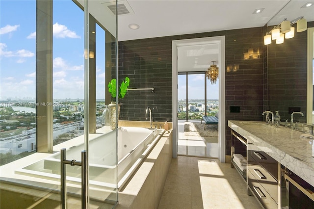 full bathroom with visible vents, a tub with jets, a city view, and vanity