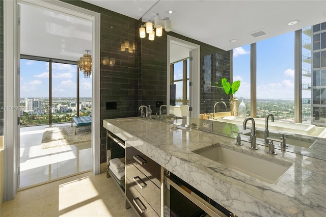 full bathroom featuring a sink, double vanity, a view of city, wine cooler, and visible vents