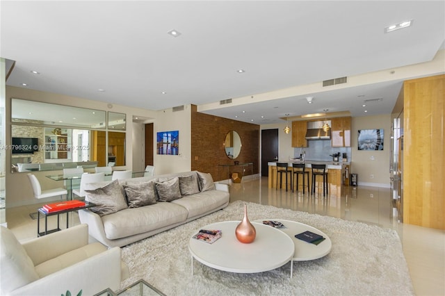 living area with baseboards, visible vents, and light tile patterned floors
