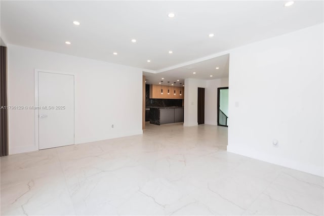 empty room with baseboards, recessed lighting, and marble finish floor