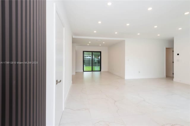 unfurnished room featuring baseboards, recessed lighting, and marble finish floor