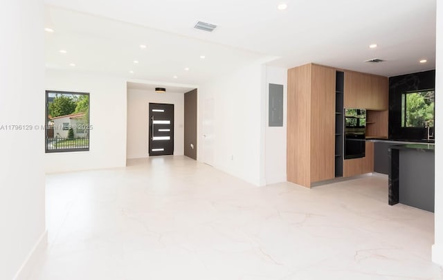 empty room featuring recessed lighting, visible vents, marble finish floor, and electric panel