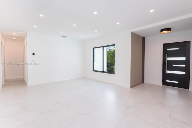 unfurnished room featuring recessed lighting and marble finish floor