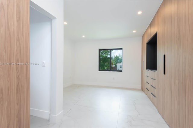 spare room featuring recessed lighting, marble finish floor, and baseboards