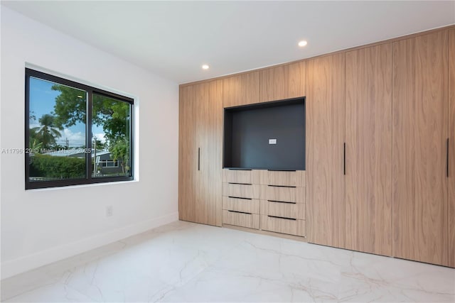 unfurnished bedroom featuring baseboards, recessed lighting, and marble finish floor