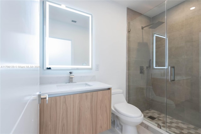 full bathroom featuring vanity, a shower stall, and toilet