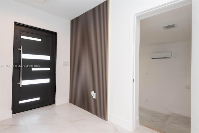 foyer with visible vents, a wall mounted air conditioner, marble finish floor, and baseboards