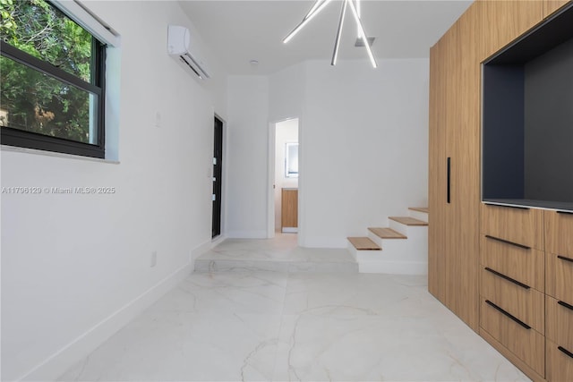interior space with an AC wall unit, baseboards, stairway, and marble finish floor