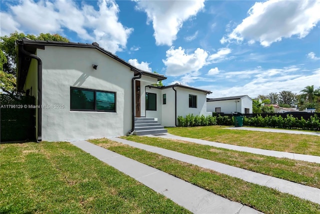 view of front facade featuring stucco siding and a front yard