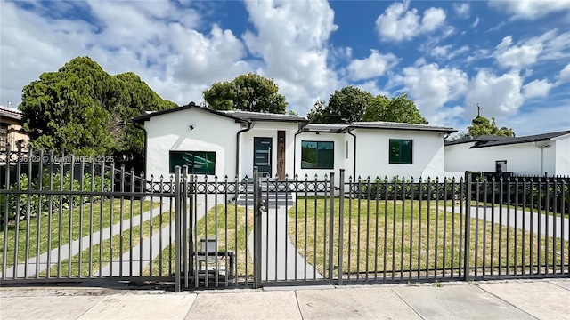 view of front of house featuring a fenced front yard, a gate, a front yard, and stucco siding