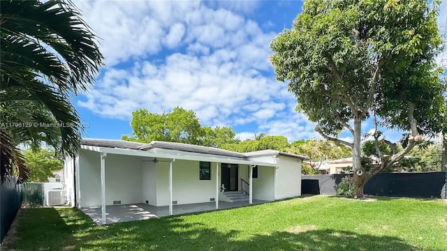 rear view of house with a ceiling fan, a patio area, a fenced backyard, a yard, and stucco siding