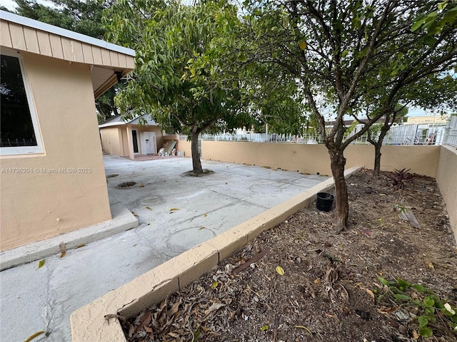 view of yard featuring a fenced backyard, an outbuilding, and a patio area
