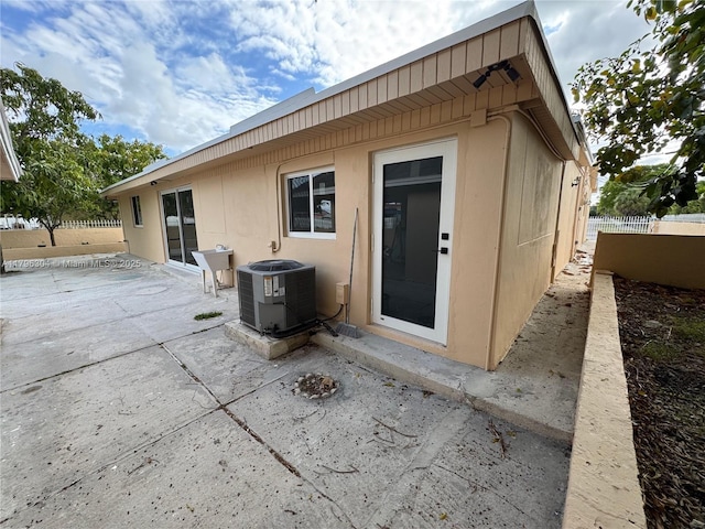 rear view of property featuring a patio area, central AC, and fence