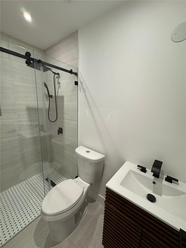 full bath with vanity, a stall shower, and toilet