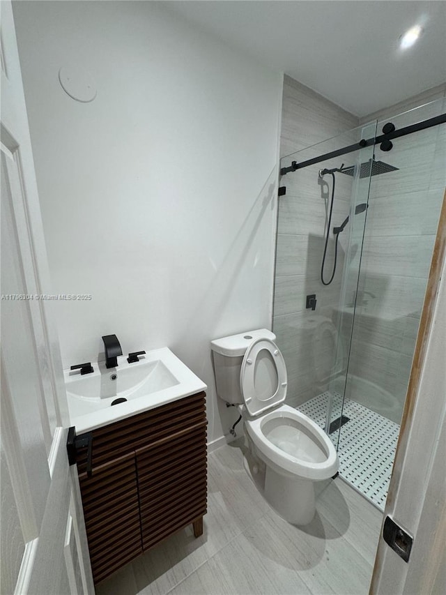 full bath featuring vanity, a shower stall, and toilet