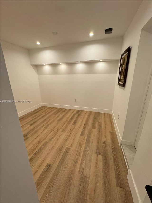 below grade area with recessed lighting, baseboards, and light wood-type flooring