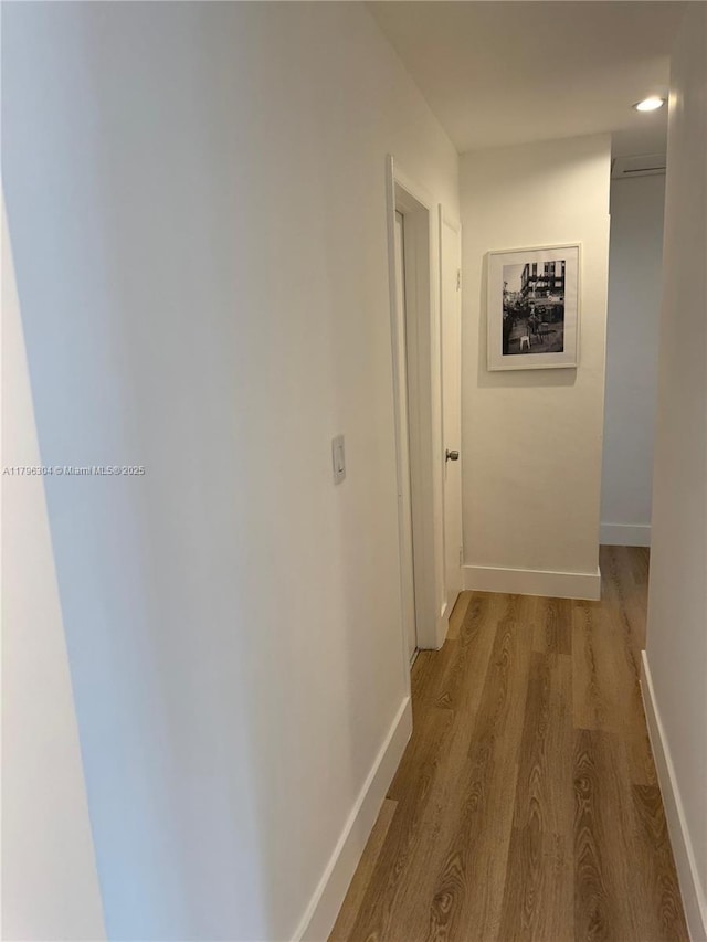 hall featuring baseboards and wood finished floors
