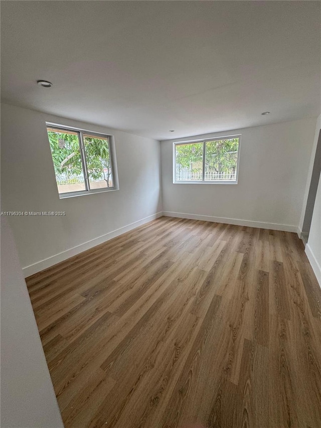 unfurnished room featuring baseboards and wood finished floors